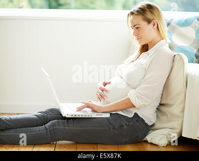 Pregnant woman using laptop computer Stock Photo