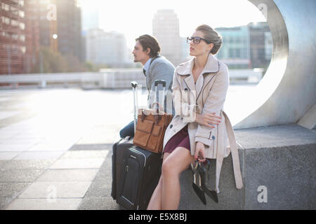 Businessman and woman waiting on city rooftop parking lot Stock Photo