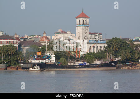 A ship and the Myanmar Port Authority building by the Yangon river in Yangon , Myanamar (Burma). Stock Photo