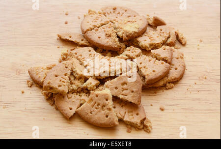 Pile of crushed digestive biscuits and crumbs on a wooden board Stock Photo