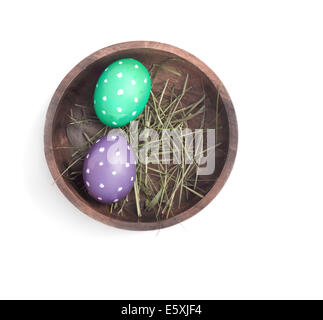 Wooden bowl with two dotted eggs over white background (dulled colors) Stock Photo