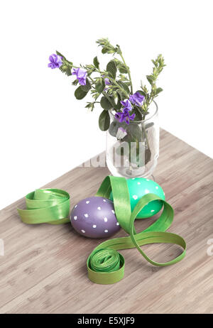 Preparing Easter decoration tools (dyed eggs, ribbon and field flowers on a wood surface) Stock Photo