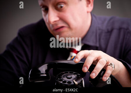 Telephone rings and the clerk is afraid of taking the call Stock Photo