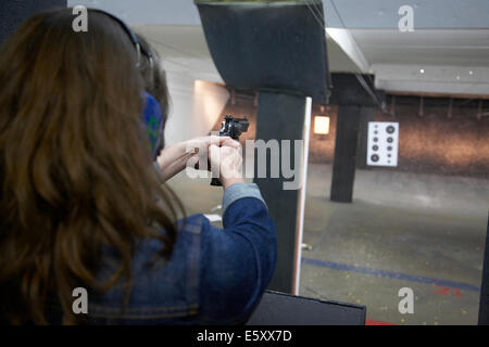 Young woman shooting a handgun at a shooting range in Minneapolis USA. Stock Photo