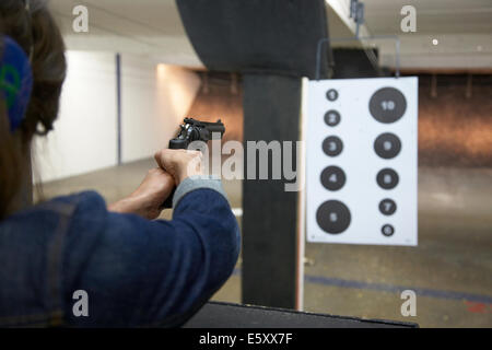 Young woman shooting a handgun at a shooting range in Minneapolis USA. Stock Photo