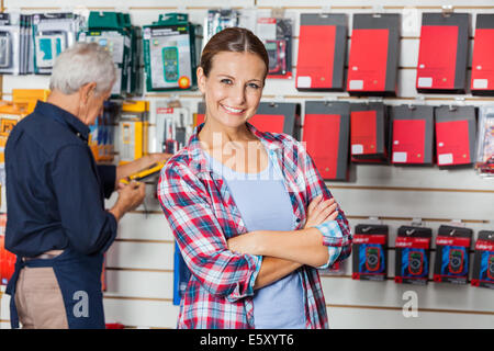 Confident Woman With Arms Crossed In Hardware Store Stock Photo