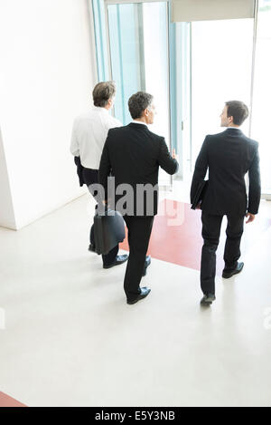 Business associates leaving office building together Stock Photo