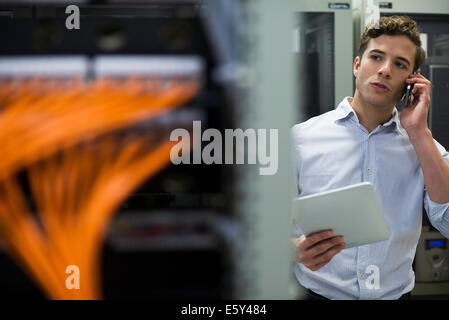 Computer technician performing maintenance check of mainframe equipment Stock Photo