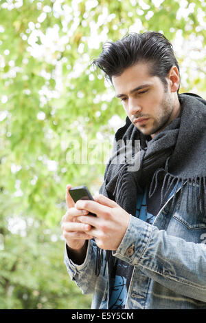 Young man using smartphone outdoors Stock Photo