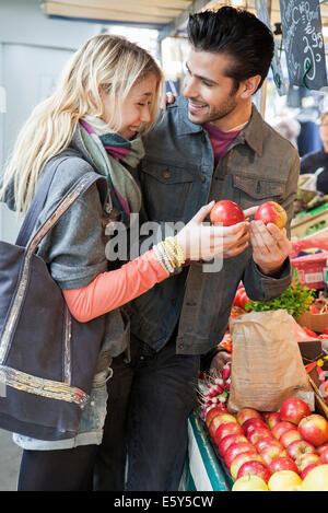 Young couple at greengrocer's shopping for fresh fruits and vegetables Stock Photo