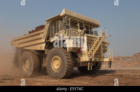 A white 200ton payload Hitatchi Diesel/ Electric hybrid hauls waste in a large open cast copper mine in Africa. Stock Photo