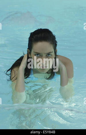Woman in pool, looking at camera Stock Photo