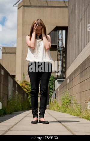 Stressed/tearful young woman with her head in her hands. Stock Photo