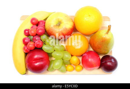 Fresh ripe fruits lying on wooden cutting board, desk of fruits, concept for healthy eating. Isolated on white background Stock Photo