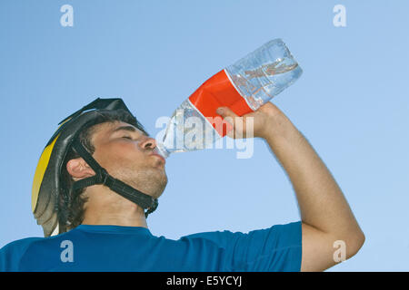 Young cyclist drinking water, view from below Stock Photo
