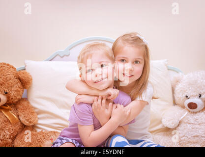 Portrait of two cute kids having fun at home, brother and sister playing in bedroom, healthy lifestyle, family love concept Stock Photo