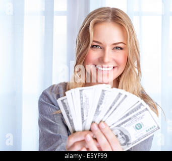 Portrait of happy excited woman holding in hands many dollars, at home, financial success, spending money, wealth concept Stock Photo