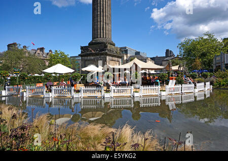 Visitors enjoying a drink under  the Melville Monument at the Edinburgh festival at St Andrew Square in Edinburgh Scotland Stock Photo