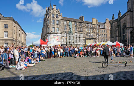 Performer surrounded by visitors to the Edinburgh Fringe Festival 2014 in W. Parliament Square Royal Mile Edinburgh Scotland Stock Photo