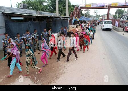 Garment workers are in a long queue to join their workplace in Ashulia in Dhaka on August 9, 2014 Stock Photo