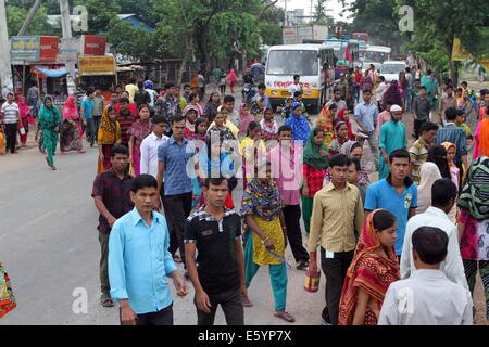 Garment workers are in a long queue to join their workplace in Ashulia in Dhaka on August 9, 2014 Stock Photo