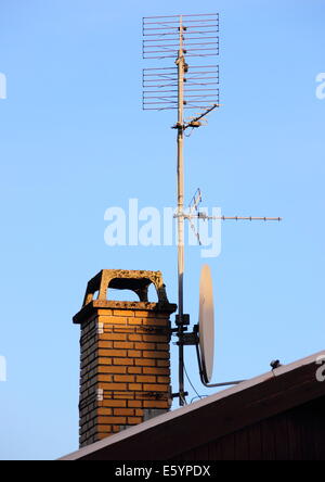 Antenna and satellite dish on a chimney Stock Photo
