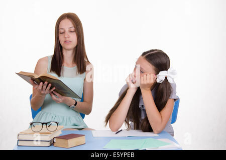 Teacher teaches the student sitting with him at the table Stock Photo