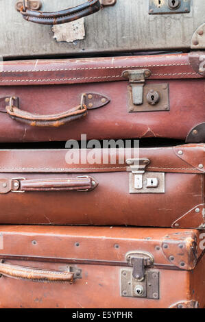 Closeup of old luggage suitcases stacked upon each other recreating a travel scene commonly seen in the 1940s, 1950s and 1960s Stock Photo