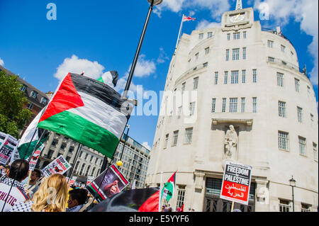 London, UK. 9th august, 2014. Outside the BBC a huge flag is unfurled and as the march heads off peace signs alternate with pointing and chanting - Shame on you. Stop the 'massacre' in Gaza protest. A demonstration called by the Palestine Solidarity Campaign (PSC). They assembled at the BBC offices in Regent Street and marched to The US Embassy and on to a rally in Hyde Park. They called for 'Israel's bombing and killing to stop now and for David Cameron to stop supporting Israeli war crimes'. London, 09 Aug 2014. Credit:  Guy Bell/Alamy Live News Stock Photo