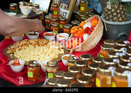 West Dean, Chichester, UK. 9th August, 2014. A visitor tastes one of the Chilli sauces on sale at one of the stalls at the Chilli Fiesta at West Dean, August 2014. UK weather.  Credit:  MeonStock/Alamy Live News Stock Photo