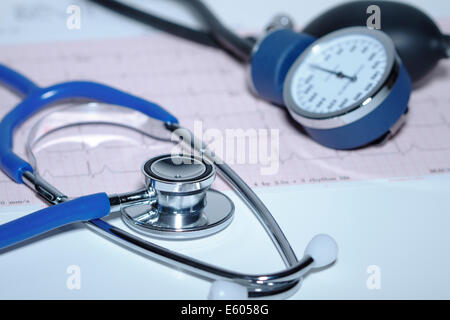Cardiology Acoustic stethoscope and aneroid sphygmomanometer on an electrocardiogram printout. Stock Photo