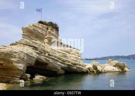 Zante, Greece - Agios Sostis resort. Greek flag flying on rock at boat landing. Stock Photo