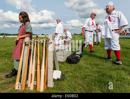 Mumford, New York, USA. 08th Aug, 2014. The Woodstock Actives players and their ''roustabout'' (bat girl) watch their side bat in their game against Spring Creek at the 12th Annual National Silver Ball Vintage Base Ball Tournament played at the Genesee Country Village and Museum. Eleven teams from around the Northeast and Midwest have gathered for this three-day, round robin tournament played by 1866 rules, including ''no gloves or other protective equipment'' permitted. Credit:  Brian Cahn/ZUMA Wire/Alamy Live News Stock Photo