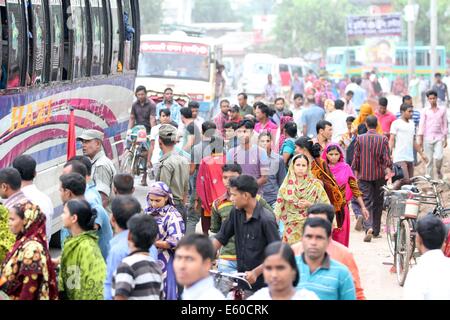 Garment workers are in a long queue to join their workplace in Ashulia in Dhaka on August 9, 2014 Stock Photo