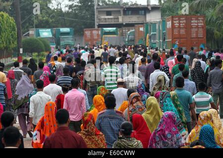 Garment workers are in a long queue to join their workplace in Ashulia in Dhaka on August 9, 2014 Stock Photo