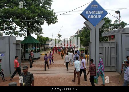 Garment workers are in a long queue to join their workplace in Ashulia in Dhaka on August 9, 2014 Stock Photo