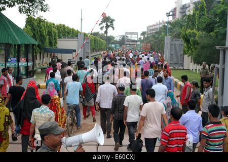 Garment workers are in a long queue to join their workplace in Ashulia in Dhaka on August 9, 2014 Stock Photo