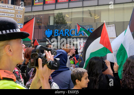 Manchester, UK. 9th August 2014. A police evidence gatherer uses a video camera to carry out overt surveillance on the pro-Palestinian protest outside Barclays Bank in Market Street. Credit:  Realimage/Alamy Live News Stock Photo