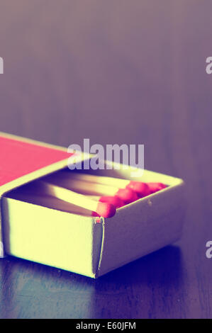 matchbox full of red matches on table Stock Photo