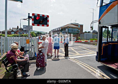 Pedestrians and traffic wait at the railway crossing at Polegate Sussex. UK Stock Photo