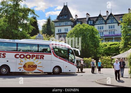 A coach drops off tourists in Strathpeffer, Scotland, UK Stock Photo