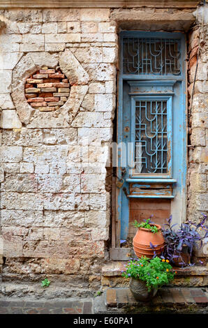 A textured old stone wall with peeling plaster and weathered surface ...