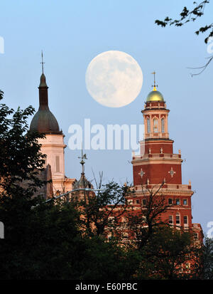 The moon appears over Yale University and New Haven, Connecticut, USA on Saturday, August 9, 2014. The full 'Supermoon' will be on August 10, 2014, when the moon is closest to the earth and appears large in the night sky. Stock Photo