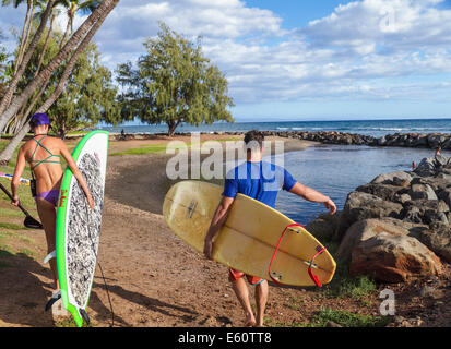 Couple with SUP and surfboard at Launiupoko State Wayside Park in Lahaina, Maui Stock Photo