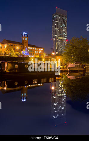 A reflection of Beetham Tower in the water at Castlefield Urban Heritage Park and canal conservation area at night, Manchester.