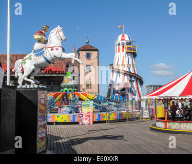 South coast sightseeing: Helter skelter and colourful fairground attractions at the funfair on Brighton Pier popular for family holidays in summer Stock Photo