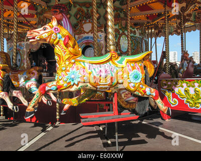 Brightly coloured horses on a merry go round at the funfair on Brighton Pier, UK on a sunny summer's day Stock Photo