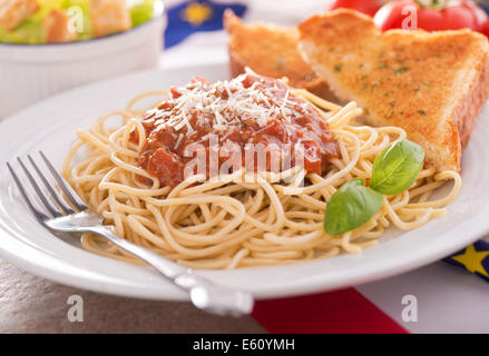 Homemade spaghetti with meat sauce, garlic bread, and caesar salad. Stock Photo