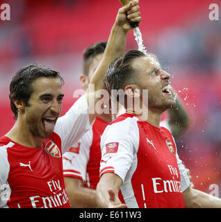 London, UK. 10th Aug, 2014. Mathieu Flamini(L) of Arsenal celebrates by spraying champagne towards his teammate Aaron Ramsey after the Community Shield match between Arsenal and Manchester City at Wembley Stadium in London, Britain on Aug. 10, 2014. Arsenal won 3-0. Credit:  Wang Lili/Xinhua/Alamy Live News Stock Photo