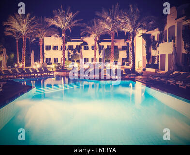 Retro vintage style picture of pool side of hotel at night. Stock Photo